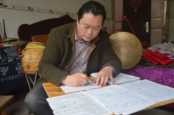 梁平癩子鑼鼓傳承人、全國優(yōu)秀文化志愿者賀志燦整理癩子鑼鼓的相關資料。通訊員 謝清城 攝